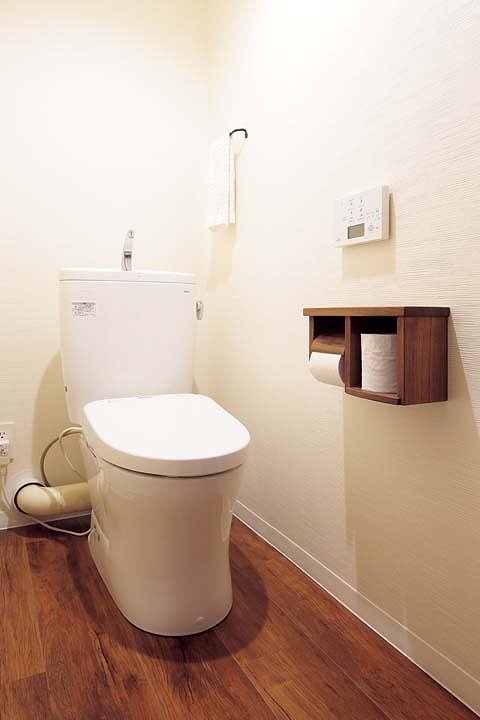 トイレは木製のペーパーホルダーや木目調のフロアタイルでウッディな雰囲気に