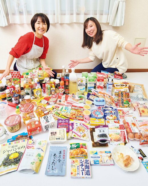 笑顔で並ぶ2人の女性の前に食材や調味料がたくさん並んでいる