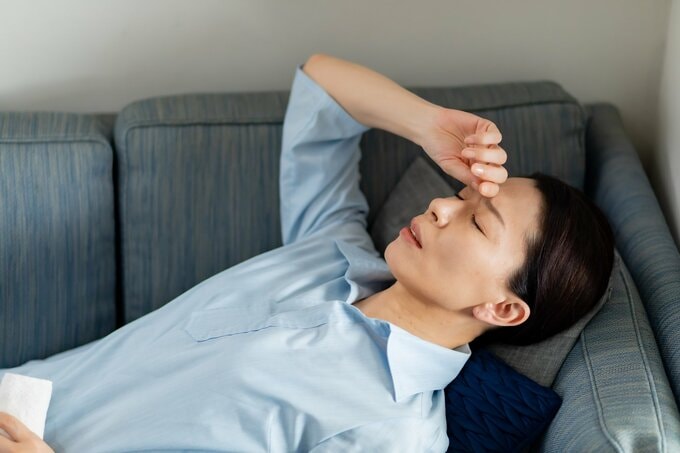 体調不良で横になる女性