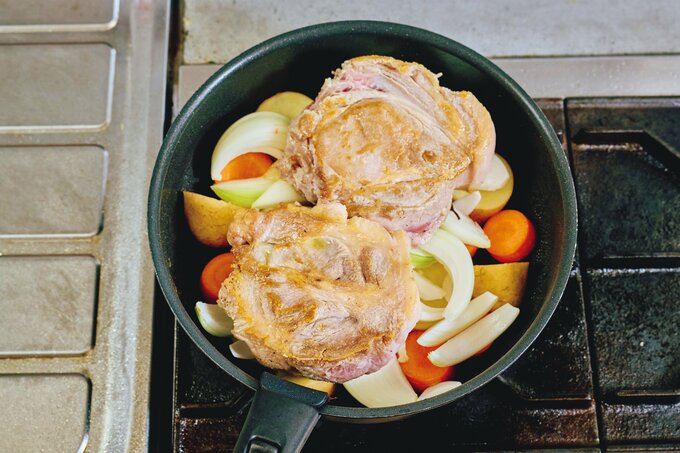 野菜の上に焼いた豚肉を乗せているところ