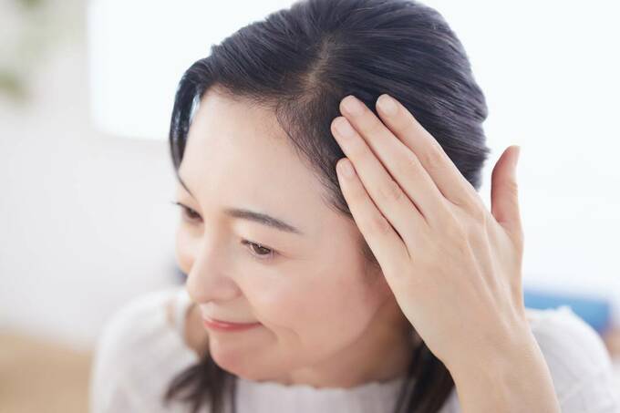 髪をおさえる女性