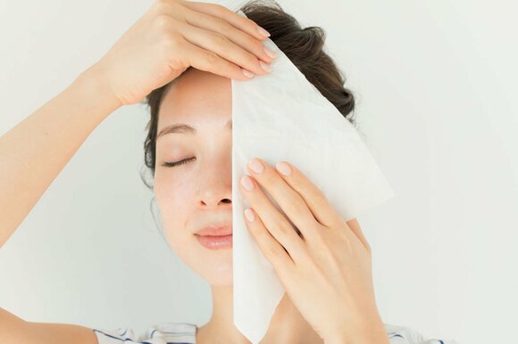 顔の半分をティッシュで隠す