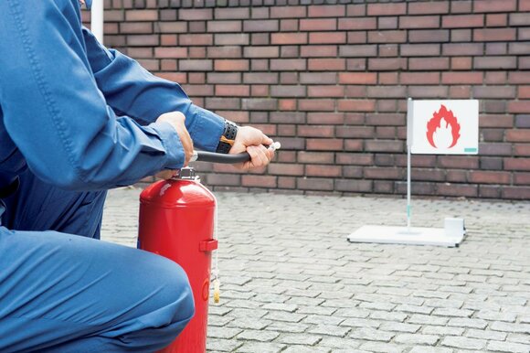 ホースの口元を手にとり、口を火元に向ける。