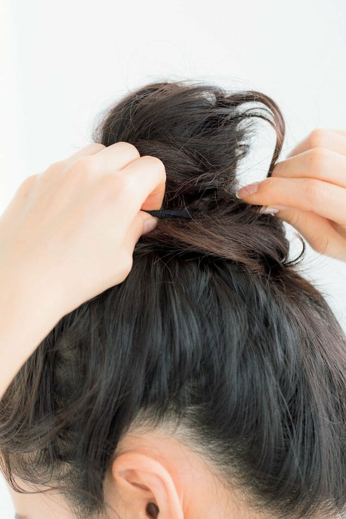 斜め後ろ女性両手でお団子つまむ