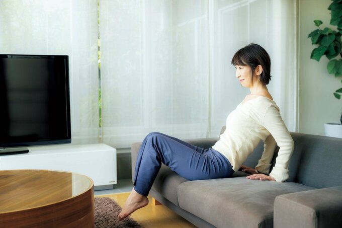 ソファに座りながら運動をする人