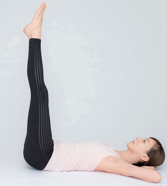 女性両手を後ろに、足をあげる