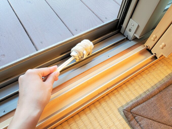 二重サッシの溝を掃除する様子