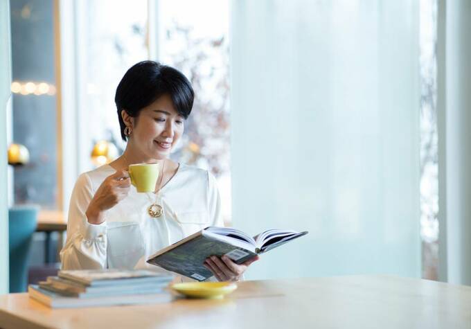 飲み物を飲みながら本を読む様子