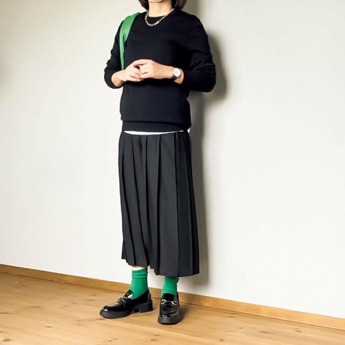 黒上下グリーン差し色の女性