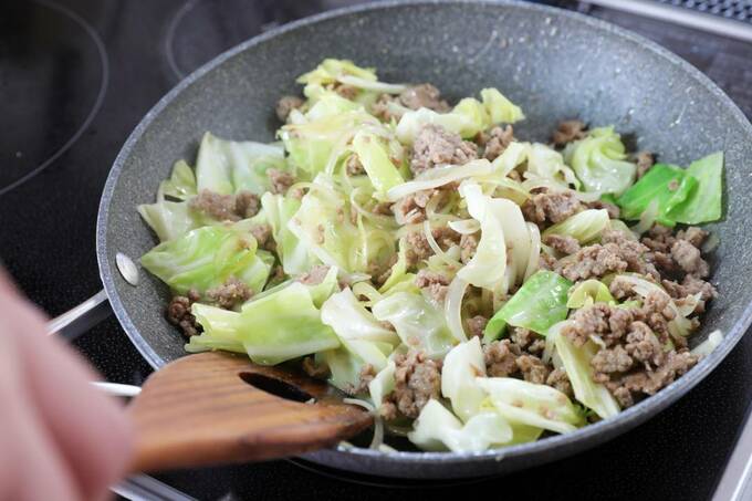 キャベツとひき肉を炒める様子