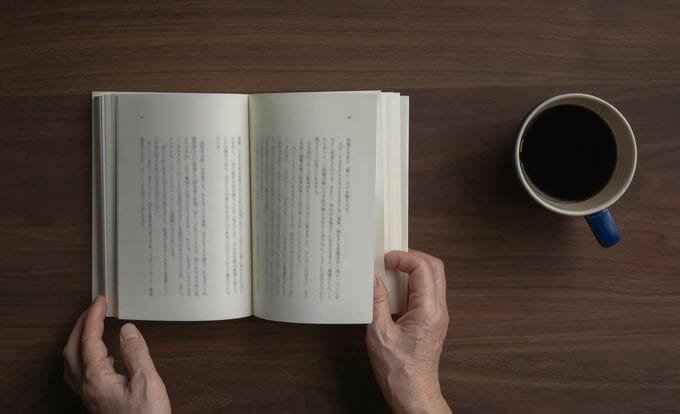 読書をする人の手元とコーヒー