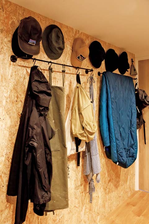 OSBボードにアイアンのハンガーパイプを取り付け、帽子や寝袋などをディスプレイ収納