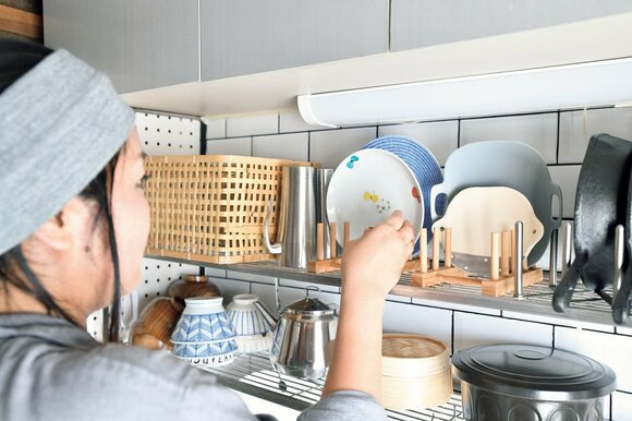 女性食器を仕舞うところ