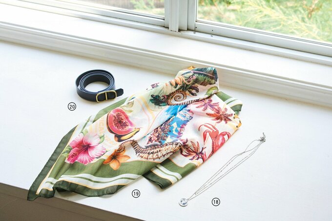 窓辺に並べられた花柄のスカーフや黒い革ベルトとネックレス