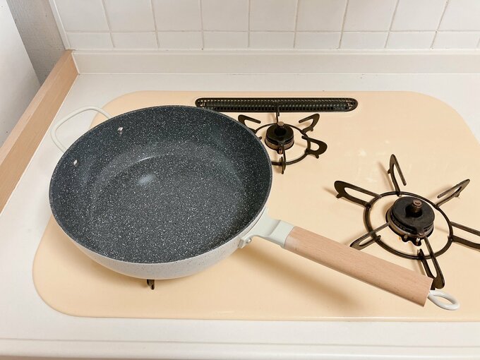 コンロの上にフライパンを置いている