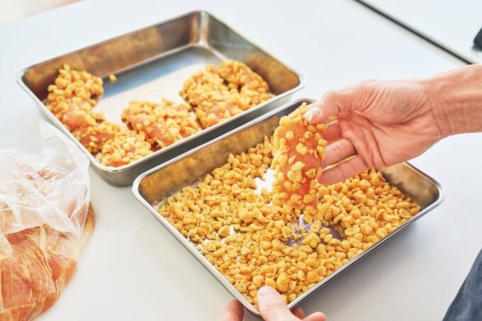 バットに広げた天かすと、天かすをまぶした鶏胸肉