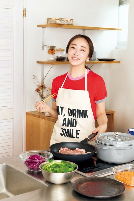フライパンで肉を焼きながら微笑む神崎恵さん