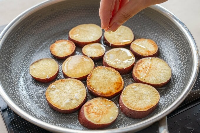 さつまいもに調味料を加えている