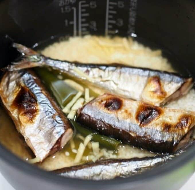 お釜にお米、ショウガ、調味料、サンマを入れる