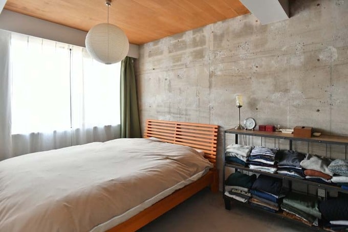 ベッドの脇に置き家具のシェルフを配置した寝室