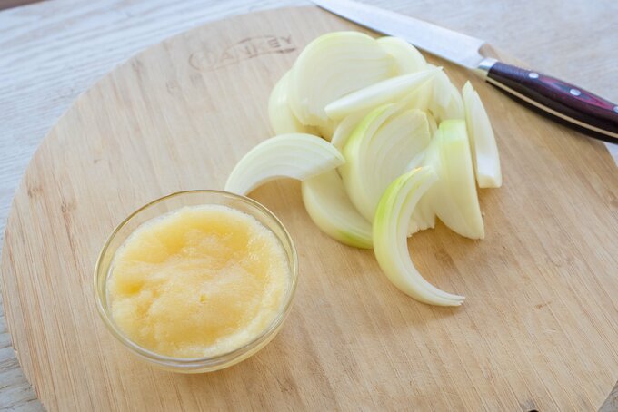 りんごは皮を剥いてすりおろす。玉ねぎは皮を剥いて、 1cm 幅のくし形切りにする。