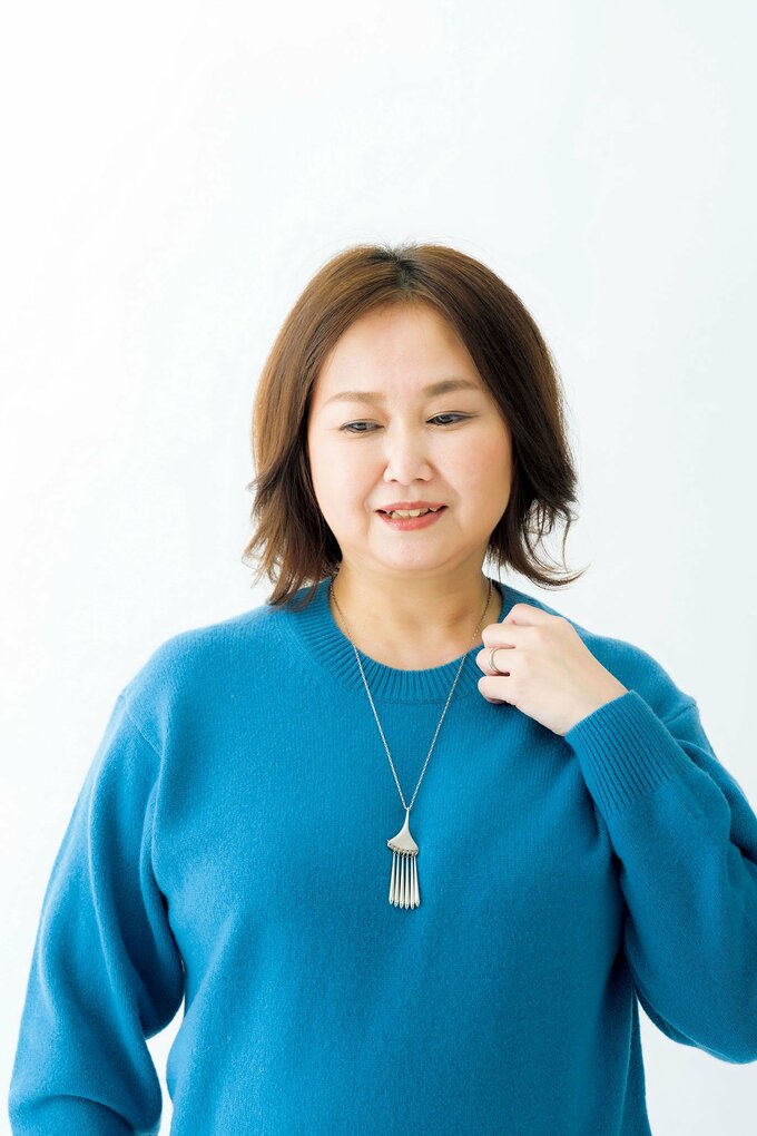 ブルークルーネックにっと着る女性