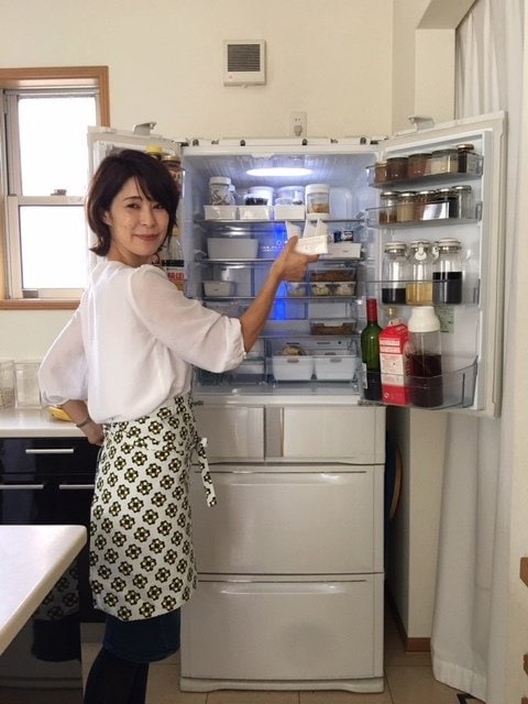 冷蔵庫収納家の福田かずみさんが冷蔵庫からものを取り出す様子