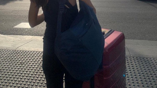 スーツケースを持った女性の後ろ姿