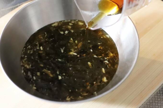 もずく酢、めんつゆ、ショウガ、ゴマ油を混ぜ合わせている様子