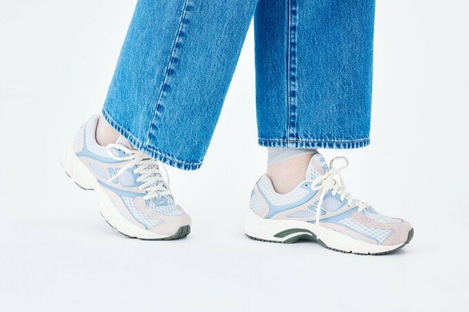 サックスブルースニーカーと透けたソックスを履いた足元