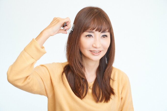 ブラシで髪をとく女性