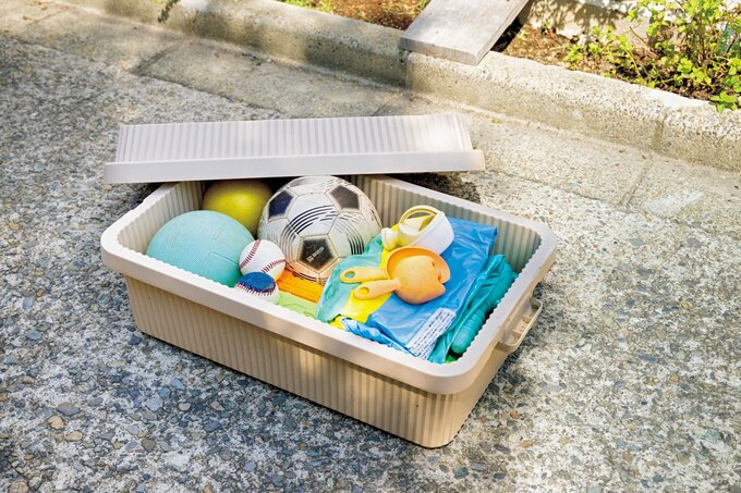 コンテナに入れられたスポーツ用品や外遊び用のオモチャ