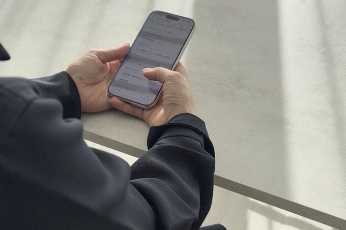 スマホを触るNozomiさんの手元