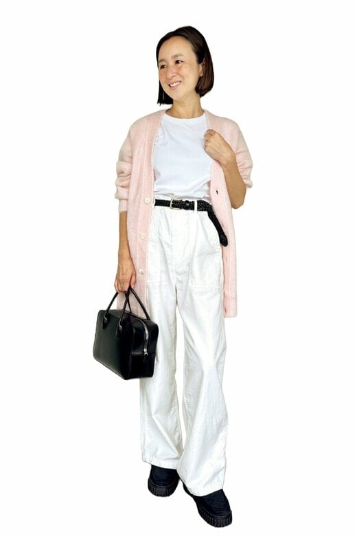 白T×白ボトムスに桃色のロングカーデと黒い小物をアクセントにしたコーデの女性