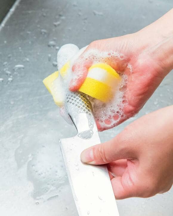 包丁の柄をスポンジで洗う
