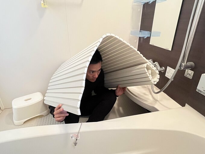 浴室での地震で頭を守る様子