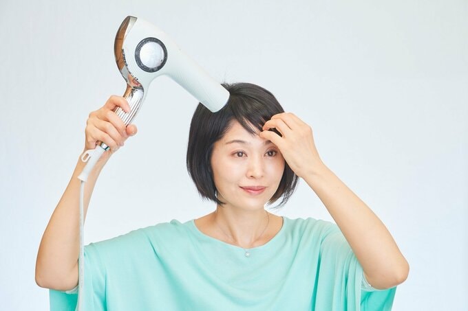 ドライヤーをあてている女性