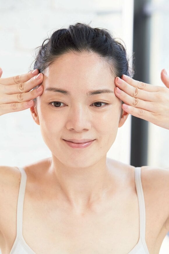 両指で額の外へひっぱる