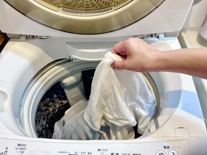 洗濯機から洗濯物を取り出している