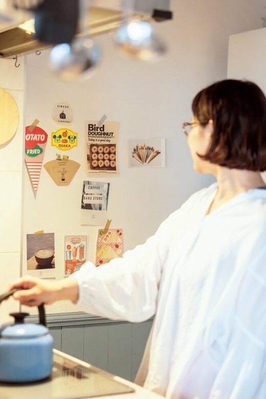 キャッチーな見た目のハガキを貼ったコンロ脇の壁