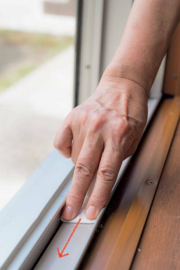 濡らしたペーパータオルと竹串でサッシを掃除する