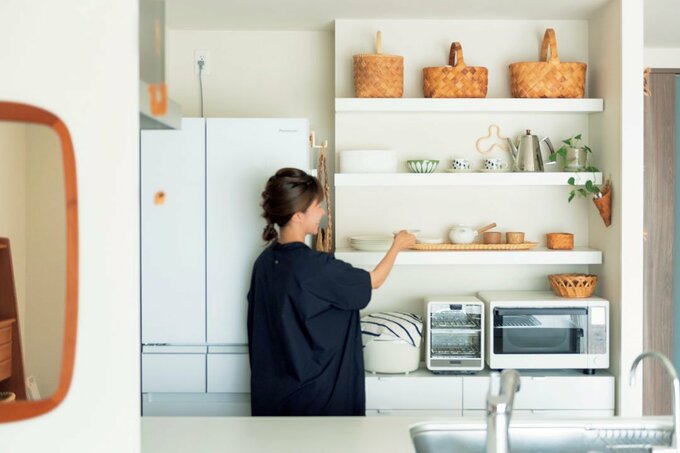 食器棚に食器を置く女性