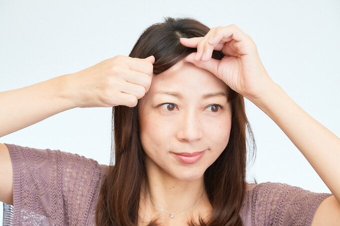 前髪を整える女性