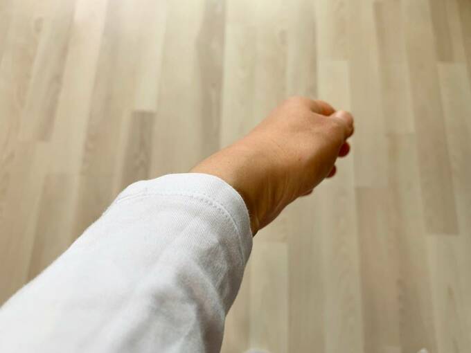 服の袖に腕を通した様子