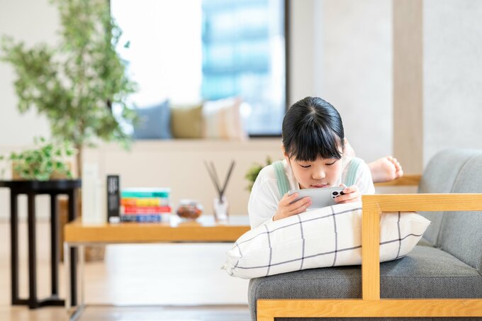 ソファでスマホを見る女の子