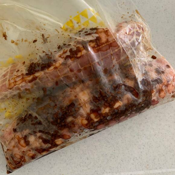 豚肉のかたまりをタコ糸でしばり、しょうゆ麹と一緒に密閉容器に入れた様子