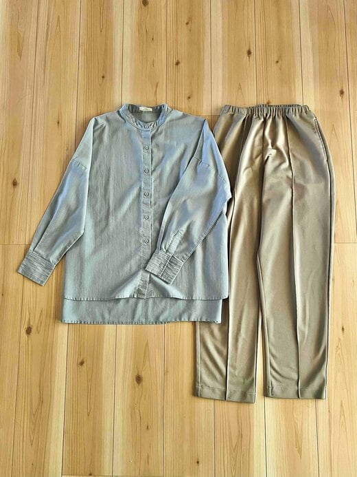 床に置かれた水色のシャツとベージュのパンツ
