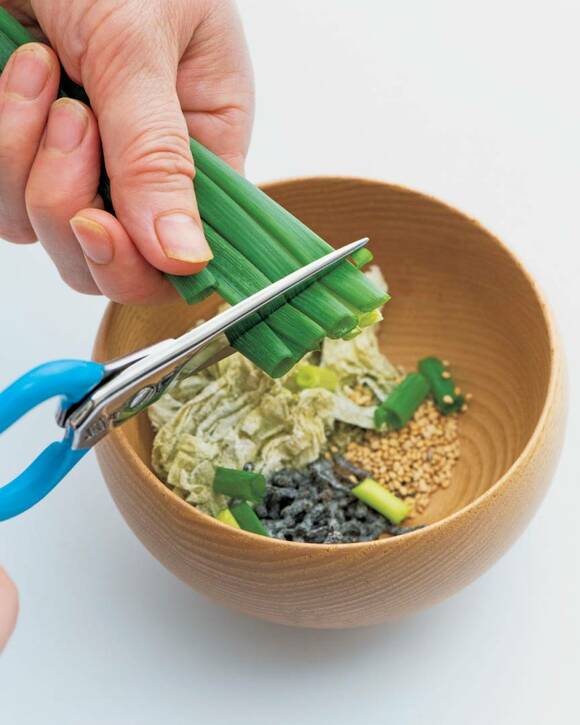 万能ネギをキッチンバサミで切りお椀に入れる