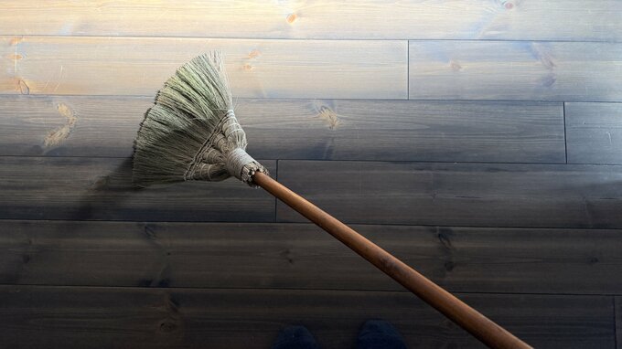 箒を床に置いている写真