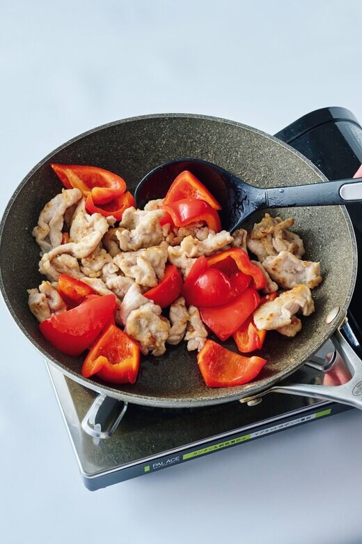 肉とパプリカをフライパンで炒める